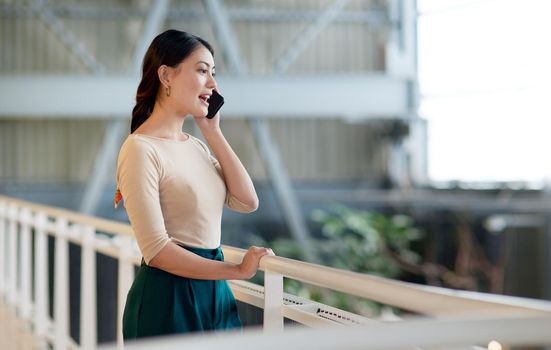 Developing customer relationships can be done by keeping communication channels open. a young businesswoman talking on a cellphone in an office.
