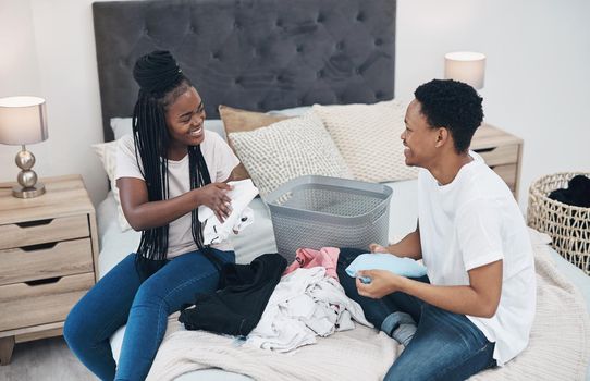 Winning in lockdown takes doing the laundry together. a young couple doing laundry together at home.