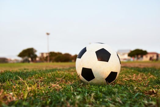 Ready for kickoff. Closeup shot of a soccer ball on an empty sports field.