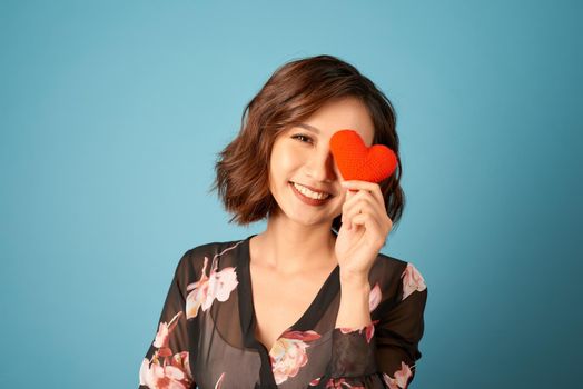 Picture of beautiful woman covering eye with heart