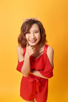 Image of a happy young beautiful asian woman posing isolated over yellow background 