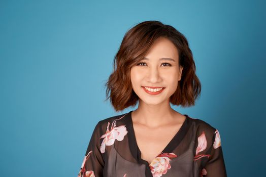 Chilling girl with short hairstyle standing in room on light blue background.