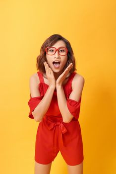 Image of screaming excited young cute woman posing isolated over yellow background.