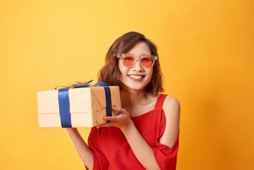 Portrait of casual young happy smiling woman hold gift box. 