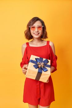 Portrait of casual young happy smiling woman hold gift box. 