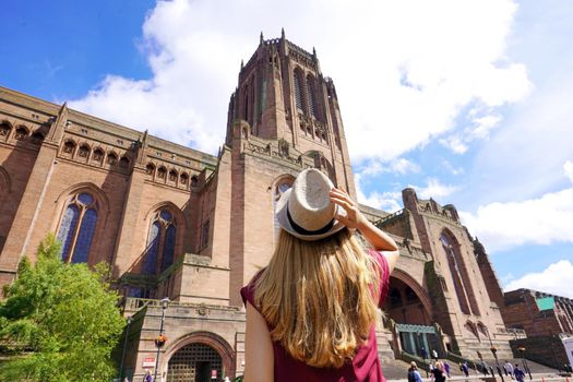 Tourism in Liverpool, UK. Back view of traveler girl visiting the Cathedral Church of Christ in Liverpool, England.