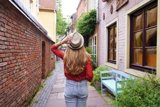 Beautiful tourist girl strolling in Schnoor neighborhood, Bremen, Germany