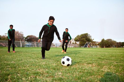 Soccer develops agility, speed and stamina. a group of young boys playing soccer on a sports field.