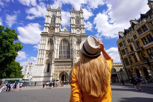 Tourism in London, UK. Back view of tourist girl visiting Westminster Abbey on sunny day in London, England.
