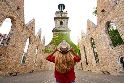 Tourism in Germany. Young woman tourist visiting the ruins of the church of Aegidienkirche destroyed during the bombing of the World War II in Hanover, Germany.