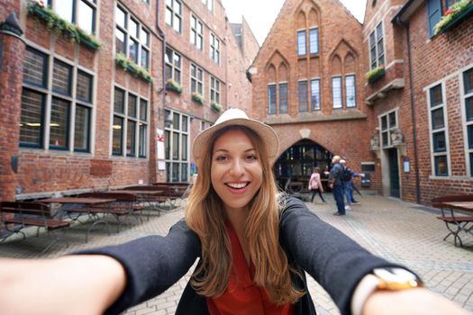 Tourist girl takes self portrait in Bottcherstrasse, Bremen, Germany