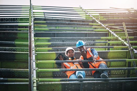 Ensuring the smooth execution of every phase of the construction process. a young man and woman working at a construction site.