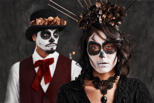 Remembering those weve lost. Cropped portrait of an affectionate young couple dressed in their Mexican-style halloween costumes.