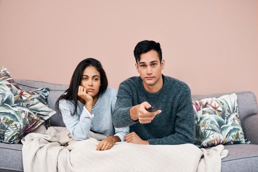 Some breaking news will clear that boredom right up. a young couple watching tv while recovering from an illness at home.