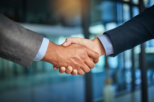 A handshake showing teamwork, collaboration and togetherness by business colleagues after a meeting in the office. A successful agreement has been reached by male coworkers in a business deal