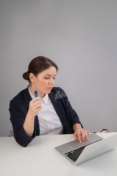 Business woman smoking a disposable vape while sitting at her desk.