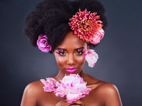 Jump on the eco-beauty trend. Studio shot of a beautiful young woman posing with flowers in her hair.