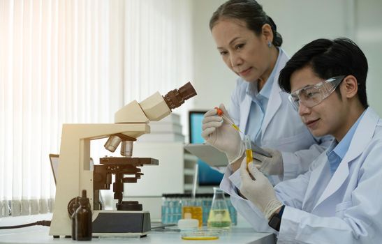 Asian scientists work in hospital pharmacology science research lab. Woman medical scientist and researchers teamwork analyzing innovative virus protective vaccines in health care biology laboratory