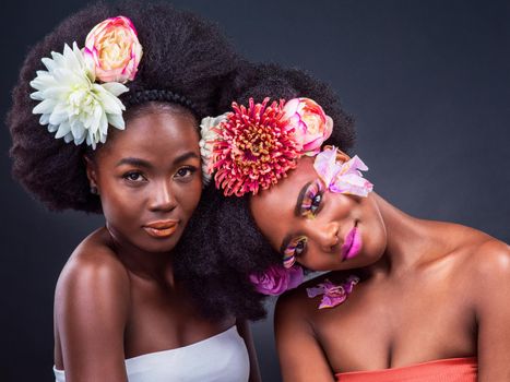You cant rush things that need time to grow. two beautiful women posing together with flowers in their hair.