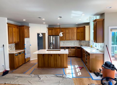 Renovated home kitchen interior with new stainless steel appliances and quartz stone countertops