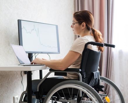 Caucasian woman on wheelchair working on laptop.