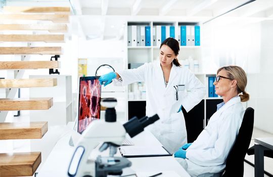 Clinical research helps translate medical discoveries into working treatments. two scientists working together on a computer in a lab.