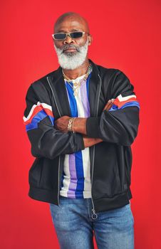 I dont play games. Studio shot of a senior man wearing retro attire while posing against a red background.
