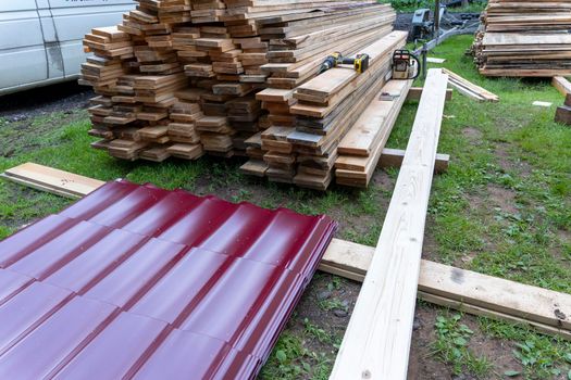 Wooden boards and roofing material stacked on the construction site