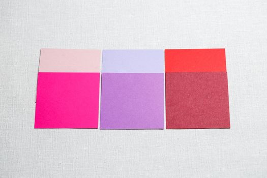 square pieces of multi-colored fabric laid out on a gray background