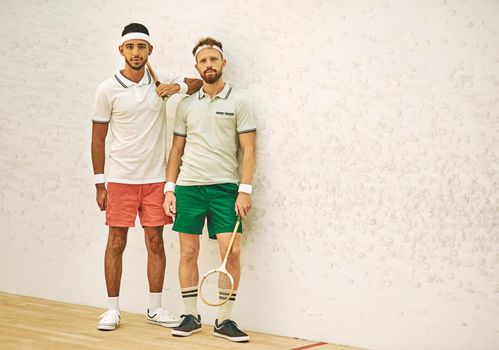Theres nobody like a squash buddy. two confident young men standing together at a squash court.
