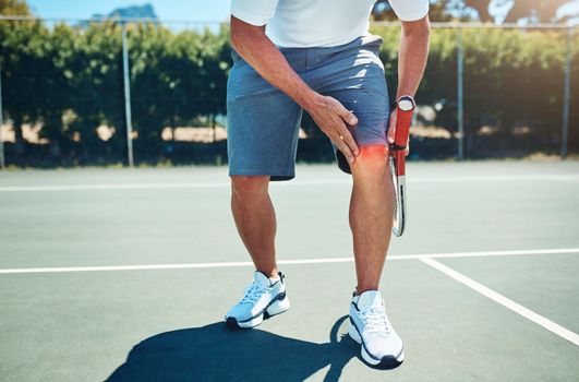 Ow My knee. an unrecognizable sportsman suffering from a knee injury while playing tennis alone.