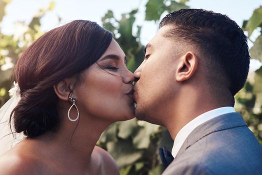 I feel sparks go off when I kiss you. a young couple sharing a kiss on their wedding day.