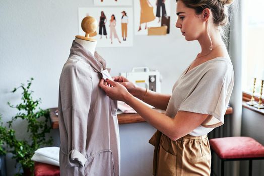 You can make anything you put your mind to. a young fashion designer working on a garment hanging over a mannequin.