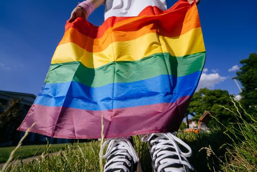 Cropped photo of young woman with LGBT pride flag.
