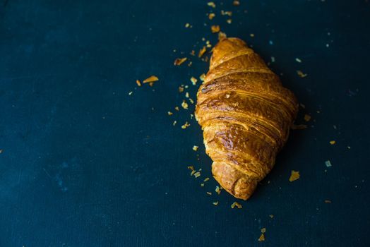 Fresh homemade french croissant on dark wooden table