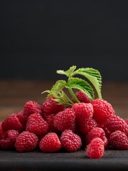 Ripe red raspberries on a brown wooden board