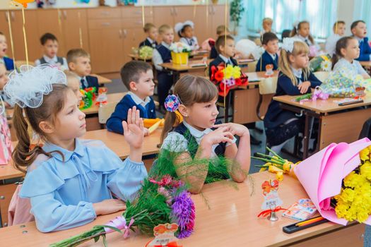 First-grade students and teacher are in school classroom at first lesson. The day of knowledge in Russia.