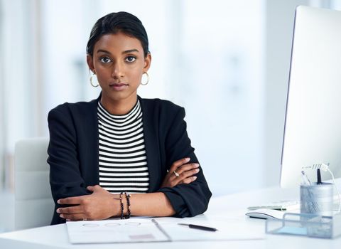 Shes serious and determined to succeed. Portrait of an attractive young businesswoman posing at her office desk at work.