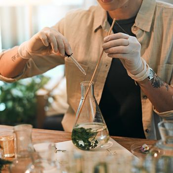 Hydroponics is the fastest growing cultivation technique in botany. an unrecognizable botanist adding a liquid nutrient to a water based plant inside a glass jar.