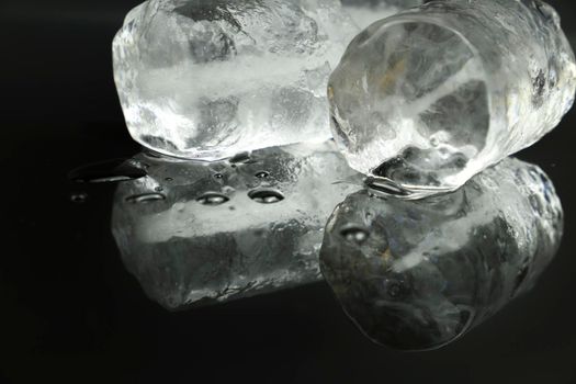 Ice cubes and reflections on black background
