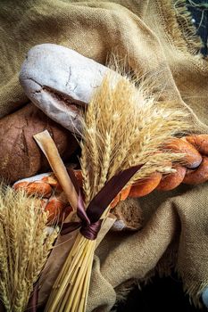 Top view of a bouquet of wheat lying on fresh bread and other bakery products as a symbol of food and agrarian well-being of the country