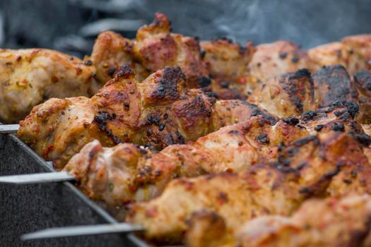 Marinated shashlik preparing on barbecue grill over charcoal.