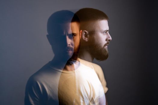 Double exposure crative portrait of man looking at camera with calm serious face.