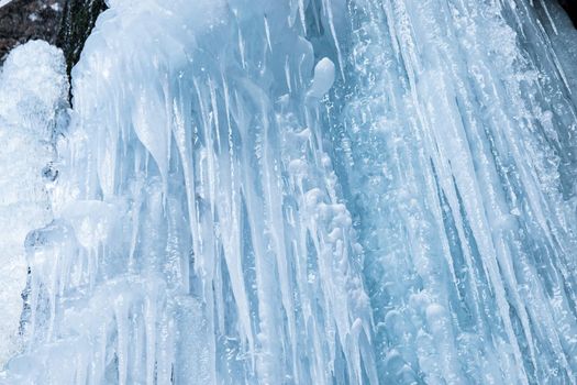 Winter background of ice, icicles and ice stalactites