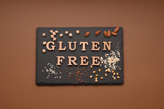 Gluten free text and spoons of various gluten free flour, almond, buckwheat, rice, corn, oat, chickpea. Flat lay, top
