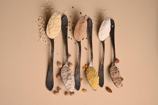 Spoons of various gluten free flour. Flat lay, top.