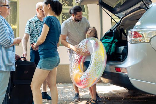 Parents with kid loading bags in trunk