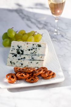 Gorgonzola cheese served outdoors with green grapes and snacks