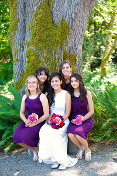 Beautiful biracial young bride smiling with her multiethnic group of bridesmaids
