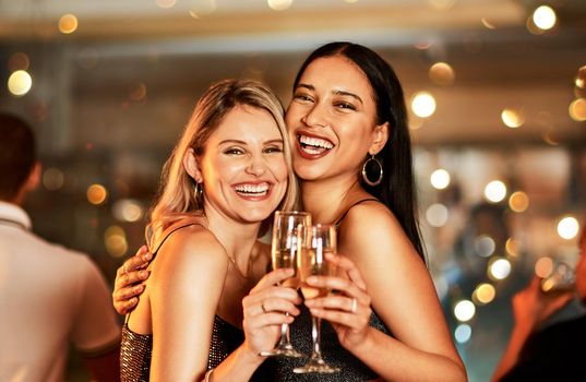 Yes shes my bestie. Portrait of two cheerful young women having drinks while dancing on the dance floor of a club at night.